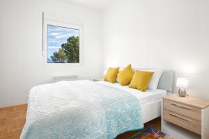a white bedroom with a bed and a window at Piskalina Apartment in Tivat