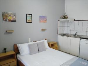 a small bedroom with a white bed and a sink at Litsa Studios in Patitiri