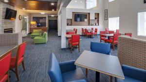 uma sala de jantar com mesas e cadeiras e mesa de cabeceira em Holiday Inn Express Hotel & Suites Detroit - Farmington Hills, an IHG Hotel em Northville