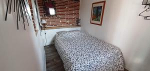Bett in einer Ecke eines Zimmers in der Unterkunft Les Hauts de Sames in Deyme