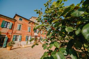 un viejo edificio de ladrillo con un árbol delante de él en Tenuta Ca' Zen, en Taglio di Po