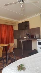 Habitación con cocina con mesa y sillas. en Amberlight Self Catering Accommodation en Krugersdorp