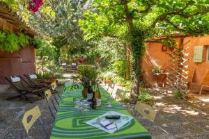 ルシヨンにあるPoterie de Pierrouxの緑のテーブルクロスを敷いた庭園のテーブル