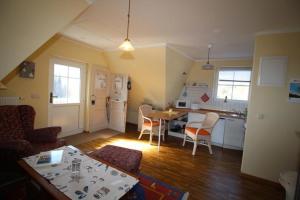 a kitchen and living room with a table and chairs at Wiesenstr_ FeWo Kirr in Zingst