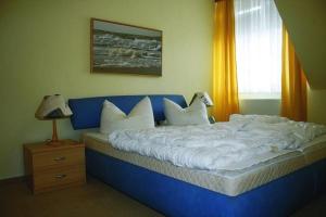 a blue bed with white pillows and a window at Strandstr_41 Fewo 1 in Zingst