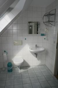 a white bathroom with a sink and a toilet at Strandstr_41 Fewo 1 in Zingst