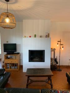 a living room with a fireplace and a tv at Villa Yeure in Camiers