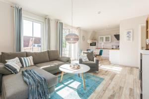 a living room with a couch and a table at Whg 12 Viktoria Luna Ostseeflair in Zingst