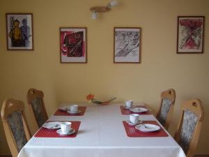 a dining room table with a white table cloth and chairs at Lindenstrassee Haus Sonnengru_ in Zingst