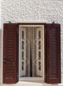 okno z brązowymi okiennicami przed budynkiem w obiekcie Stella Bianca w mieście Savelletri di Fasano