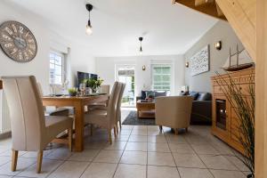 a dining room and living room with a table and chairs at Alte Reihe 14 _Haus Teja_ in Zingst