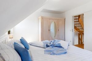 a bedroom with a white bed with blue pillows at Alte Reihe 14 _Haus Teja_ in Zingst