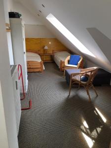 a attic room with two beds and a chair and a staircase at Strandstr_51 Wohnungsnr_11 in Zingst