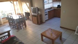 cocina y sala de estar con mesa y TV en Terrazas - Andarlibre en San Martín de los Andes