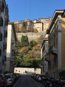 a city street with buildings and a hill in the background at DIETRO L' ANGOLO Charme&Relax nel centro città in Bergamo