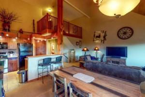 a living room with a wooden table and a kitchen at The View from the Pines in Golden