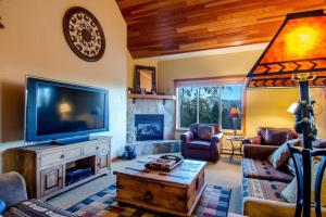a living room with a television and a fireplace at The View from the Pines in Golden