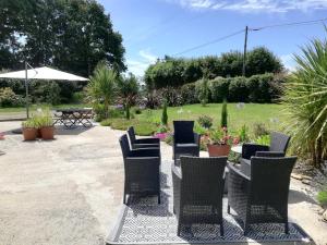 um grupo de cadeiras e uma mesa num jardim em Jolie maison près de la mer au calme Seaside Country Cottage em La Forêt-Fouesnant