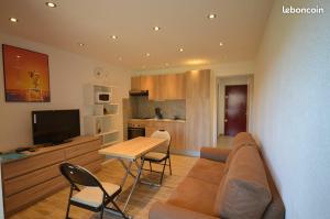 a living room with a couch and a table and chairs at le studio du lac in Les Salles-sur-Verdon