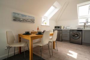 uma cozinha com uma mesa de jantar e cadeiras em The Loft, Cloughey em Kirkistown