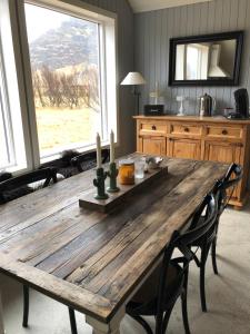 a wooden table in a kitchen with a large window at Grund Cabin in Hvolsvöllur