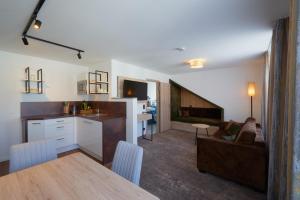 a kitchen and living room with a couch and a table at Schneider APARTMENT ALLERSBERG in Allersberg