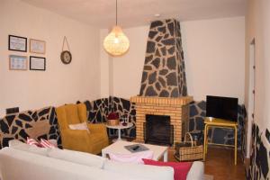 sala de estar con sofá y chimenea en Casa Rural La Salamandrija- con piscina- petfriendly, en Cordobilla de Lácara