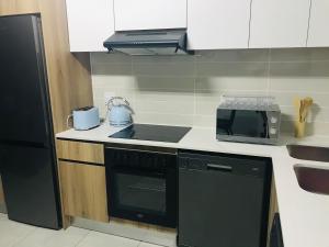 a kitchen with a stove top oven and a microwave at The blyde Pretoria unit 1244 in Pretoria