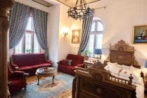 a living room with red furniture and a chandelier at Royal Residence 1901 in Sinaia