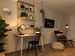 a room with a desk and two chairs and a tv at Townhouse Design Hotel & Spa in Maastricht
