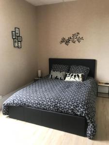 a bedroom with a bed with a black and white comforter at Chambre de la Poterie in Accolay