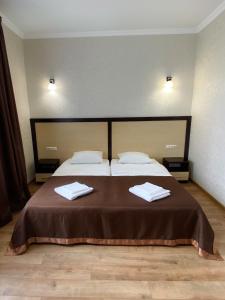 a bedroom with a bed with two towels on it at Hotel Koral in Chernivtsi