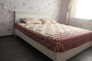 a bed with two pillows on it in a bedroom at Элитная квартира на набережной реки Иртыш in Pavlodar