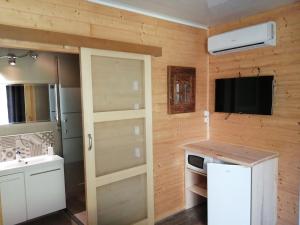 a kitchen with a refrigerator and a tv on a wall at La Villa Saint André - Argeles sur mer in Argelès-sur-Mer