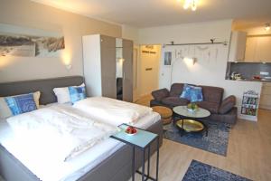 a bedroom with a bed and a living room with a couch at Freya in Westerland