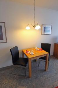 een eettafel met 2 stoelen en een licht bij Seestern in Westerland