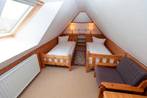 Zimmer im Dachgeschoss mit 2 Betten und einem Sofa in der Unterkunft Strandrose in Wenningstedt-Braderup