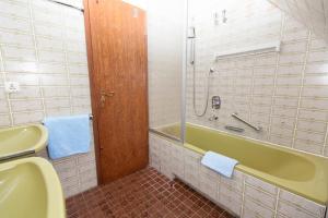 ein Badezimmer mit einer grünen Badewanne und einem Waschbecken in der Unterkunft Strandrose in Wenningstedt-Braderup