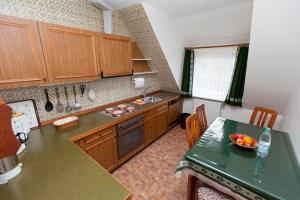 eine Küche mit Holzschränken und einem Tisch mit einer Schale Obst in der Unterkunft Strandrose in Wenningstedt-Braderup