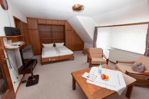 Zimmer mit einem Schlafzimmer mit einem Bett und einem Tisch in der Unterkunft Strandiris in Wenningstedt-Braderup