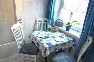 a table and chairs in a room with a window at Blaue Huis in Wenningstedt