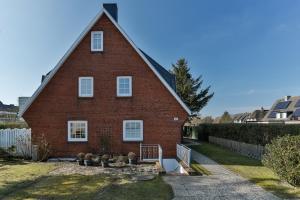 a red brick house with a gambrel roof at Nelle 1 Stock in Wenningstedt