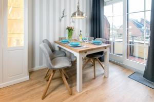 a dining room table with two chairs and a table with glasses at Sylt Liebe in Wenningstedt +2 photos