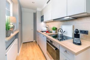 a kitchen with white cabinets and a stove top oven at Sylt Liebe in Wenningstedt
