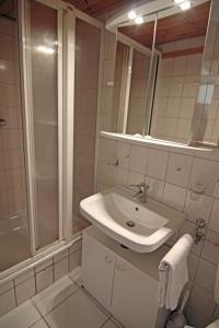 a white bathroom with a sink and a shower at Möwe in Westerland