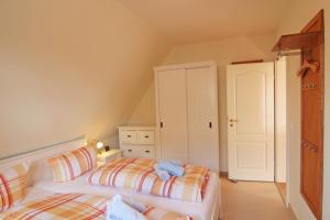 a bedroom with two beds and a dresser at Ose in Wenningstedt