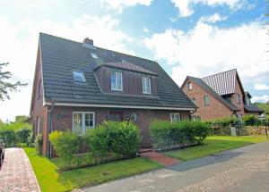 a brown house with a black roof at Ose in Wenningstedt