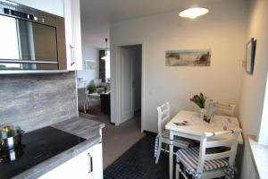 - une cuisine et une salle à manger avec une table et des chaises dans l'établissement Weller, à Wenningstedt
