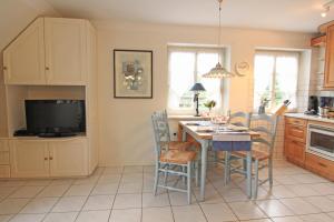 a kitchen with a table with chairs and a tv at Christine - Munkmarsch in Munkmarsch