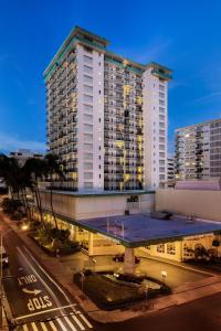 ein großes Gebäude mit einem blauen Dach vor einer Straße in der Unterkunft Waikiki Resort Hotel in Honolulu